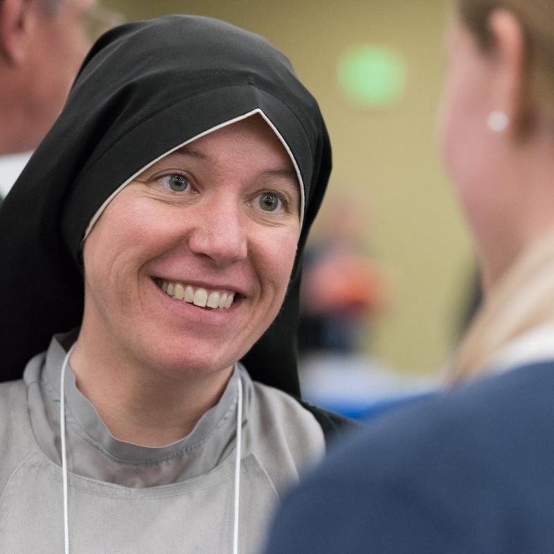 A visiting sister talking with a University of Mary student.